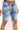 Men's blue washed Loagan denim shorts with distressed detail, orange drawstring, and Carbon Jeans waistband.