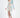 A model poses in a long-sleeve, abstract-patterned dress with a cutout detail and a thigh-high slit.