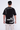 Back view of a black oversized Survive streetwear t-shirt with white graphic text on the shoulder and hem.