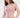 A model poses in a light pink bodysuit with cut-out sides, paired with matching relaxed-fit pants.