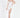A model poses in a fitted white dress with a thigh-high slit, paired with nude ankle-strap heels.