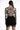 Back view of Elora long-sleeve nude bodysuit with black baroque print, paired with a black lace-trim mini skirt.