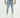 Men's light blue super skinny fit jeans with distressed details and ripped knees on a model wearing white sneakers.