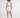 Back view of woman wearing Gyda two-piece set featuring white ribbed crop top and matching lace-up mini skirt.