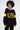 Model in black ALPES oversized long sleeve ribbed knit top with yellow block lettering and athletic sleeve stripes.
